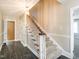 Carpeted staircase with wooden railing and white trim leads to the upper level at 223 Shadowbrook Dr, Burlington, NC 27215