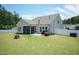 A well-manicured backyard featuring green grass, a fire pit, and a white fence at 2501 Impulsion Dr, New Hill, NC 27562