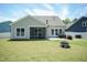 A full backyard view showcasing the patio, screened-in area, and lush green grass at 2501 Impulsion Dr, New Hill, NC 27562