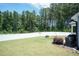The large backyard is surrounded by a white fence and mature trees at 2501 Impulsion Dr, New Hill, NC 27562