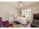 Neutral bedroom with ceiling fan, wood-look floors, and bright window with view of neighborhood at 2501 Impulsion Dr, New Hill, NC 27562