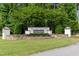 Beautiful community entrance sign with lush greenery and stone accents that welcomes residents and guests at 2501 Impulsion Dr, New Hill, NC 27562