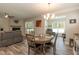 A dining area features a round table, a view of the living room, and hardwood-style floors at 2501 Impulsion Dr, New Hill, NC 27562