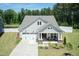 Charming home with a well-manicured lawn, American flag, and a covered porch for relaxing at 2501 Impulsion Dr, New Hill, NC 27562