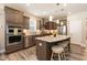 A modern kitchen with stainless steel appliances, a large island, and beautiful countertops and cabinets at 2501 Impulsion Dr, New Hill, NC 27562