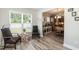 A cozy sitting area showing a glimpse into the dining and kitchen areas with natural light and neutral colors at 2501 Impulsion Dr, New Hill, NC 27562