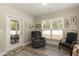 A living area with a comfortable recliner, a window with blinds, and an exterior door at 2501 Impulsion Dr, New Hill, NC 27562