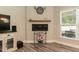 Living room nook featuring a fireplace, wood floors, and large window with great natural light at 2501 Impulsion Dr, New Hill, NC 27562