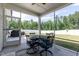 Screened porch with outdoor dining table and view of backyard and fence at 2501 Impulsion Dr, New Hill, NC 27562