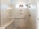 Tiled shower with frameless glass enclosure, pebble floor, grab bar, niche and rainfall shower head at 2501 Impulsion Dr, New Hill, NC 27562