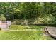 Wooded backyard with a multi-level deck and stone walkway at 2805 Evans St, Durham, NC 27705