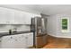 Bright kitchen featuring white cabinetry and black countertops with stainless steel appliances and hardwood flooring at 2805 Evans St, Durham, NC 27705