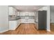 Bright kitchen featuring white cabinetry, stainless steel appliances, and warm hardwood flooring at 2805 Evans St, Durham, NC 27705