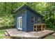 Charming shed with windows and double doors, set on a wooden deck surrounded by lush greenery at 2805 Evans St, Durham, NC 27705
