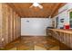Shed interior featuring paneled walls, ceiling fan, unique flooring, and ample storage and workspace at 2805 Evans St, Durham, NC 27705
