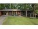 Charming, single-story home with dark exterior paint, bright trim, a level lawn and mature shade trees at 307 Yowland Rd, Henderson, NC 27536