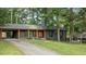 Charming, single-story home with dark exterior paint, bright trim, a level lawn and mature shade trees at 307 Yowland Rd, Henderson, NC 27536