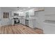 Bright kitchen featuring white cabinets, stainless steel appliances, and stylish new flooring at 307 Yowland Rd, Henderson, NC 27536