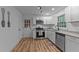 Bright kitchen featuring white cabinets, stainless steel appliances, and stylish new flooring at 307 Yowland Rd, Henderson, NC 27536