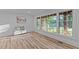 Bright, neutral living room with large windows offering wooded views and stylish flooring at 307 Yowland Rd, Henderson, NC 27536