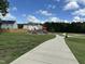 Community playground featuring modern equipment, walking path, and ample green space at 3124 Mackinac Island Ln, Raleigh, NC 27610