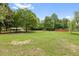 Large backyard with trees and pool in the distance, providing ample space for outdoor enjoyment at 3208 Wilbon Ridge Dr, Holly Springs, NC 27540