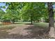 Lush backyard with mature trees and a pool, creating a private and serene outdoor space at 3208 Wilbon Ridge Dr, Holly Springs, NC 27540