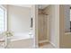 Bathroom featuring a tub and shower, along with a window that provides natural light at 3208 Wilbon Ridge Dr, Holly Springs, NC 27540