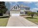 Charming two-story home featuring a two-car garage, well-manicured lawn, and classic architectural details at 3208 Wilbon Ridge Dr, Holly Springs, NC 27540
