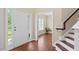 Bright foyer with a white front door, wood floors, and staircase with wooden banister at 3208 Wilbon Ridge Dr, Holly Springs, NC 27540