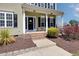 Inviting front porch with brick steps, complemented by manicured landscaping and charming design at 3208 Wilbon Ridge Dr, Holly Springs, NC 27540