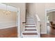 Hallway showing the staircase and hardwood floors that connect various rooms at 3208 Wilbon Ridge Dr, Holly Springs, NC 27540