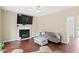 Cozy living room with fireplace, ceiling fan, hardwood floors and modern gray furniture at 3208 Wilbon Ridge Dr, Holly Springs, NC 27540