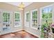 Bright sunroom with three windows overlooking lush greenery and a door to a patio at 3208 Wilbon Ridge Dr, Holly Springs, NC 27540