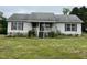 A single-story house with a sloped roof and small front porch in need of maintenance and landscaping at 3213 Sam Usry Rd, Oxford, NC 27565