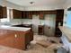 Interior image of a kitchen showing outdated wooden cabinets, missing appliances, and signs of needed repair at 3213 Sam Usry Rd, Oxford, NC 27565