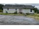 Rear view of a house showing siding, small windows, and a rear door with a dilapidated paved parking area at 3213 Sam Usry Rd, Oxford, NC 27565