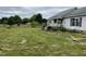 A house is shown with a weedy yard and a well structure in the background. It needs mowing at 3213 Sam Usry Rd, Oxford, NC 27565