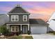 Charming two-story home with gray siding, a two car garage and a covered front porch at 34 Tanglewood Pl, Angier, NC 27501