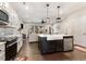 Open concept kitchen with island, stainless appliances, white cabinets, and wood flooring at 34 Tanglewood Pl, Angier, NC 27501