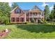 Traditional brick home featuring red shutters, a spacious front lawn, and an inviting two-story entrance at 3404 Mount Pisgah Way, Cary, NC 27519