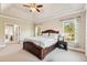 Bright main bedroom boasts tray ceilings, ceiling fan and a view to the outdoor scenery at 3404 Mount Pisgah Way, Cary, NC 27519