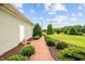 Paved path with landscaping and mature trees leads to a side entrance of the home at 360 Country Way, Sanford, NC 27332