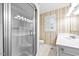 Small bathroom with a glass shower, window with shutters, and a sink with a vanity and vintage wallpaper at 360 Country Way, Sanford, NC 27332