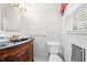 This quaint bathroom is well-lit and features a wood vanity, a dark granite sink, and gold hardware at 360 Country Way, Sanford, NC 27332