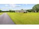 Single story home featuring a beautiful front lawn, mature landscaping, and a long driveway at 360 Country Way, Sanford, NC 27332