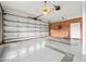 The large three car garage has brick accent walls, multiple entrances, and a ceiling fan at 360 Country Way, Sanford, NC 27332