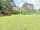 Backyard with grass and tall trees at 3716 Rivermont Rd, Durham, NC 27712