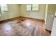 Bedroom with damaged wood floors, light colored walls, and windows at 3716 Rivermont Rd, Durham, NC 27712