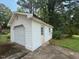 White detached garage with roll up door and side entry door at 3716 Rivermont Rd, Durham, NC 27712
